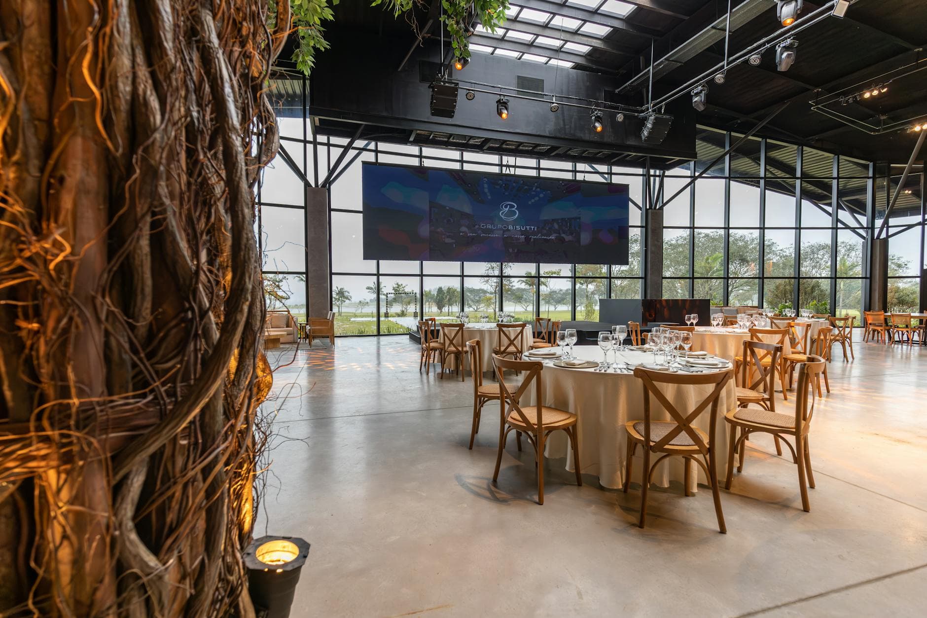 Modern corporate banquet venue with crossback chairs and screen